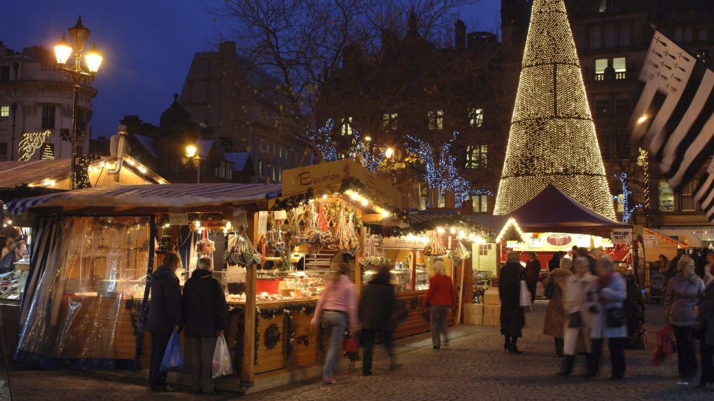 night view of people shopping at Manchester's Christmas market in Albert Square