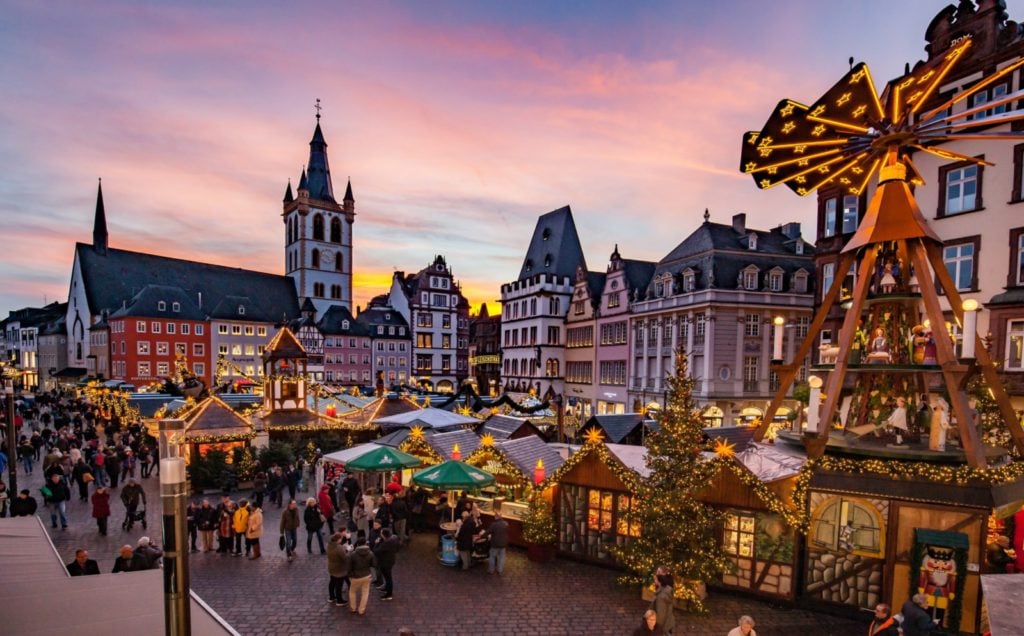 Dusk at the Trier Christmas Market in Germany with vendor stalls and people walking