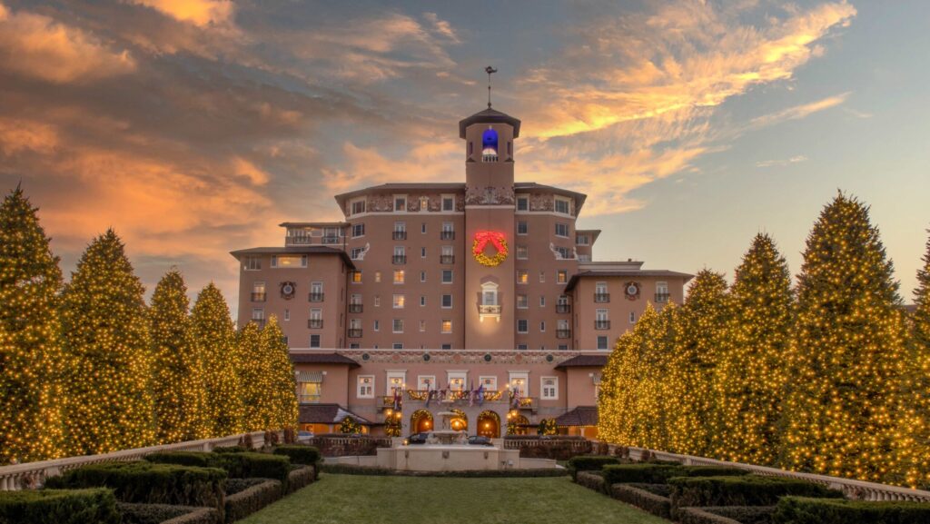 A sunset view of the exterior of The Broadmoor decorated for Christmas