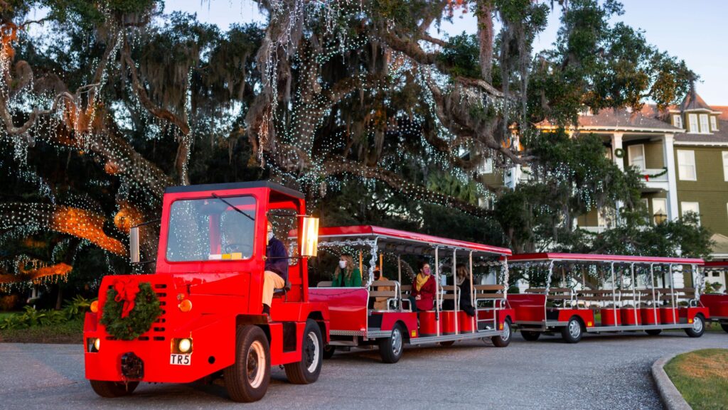 A red trolley leading a tour of Christmas lights around Jekyll Island