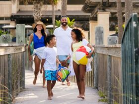 A family on a boardwalk heading to the beach with a beach ball