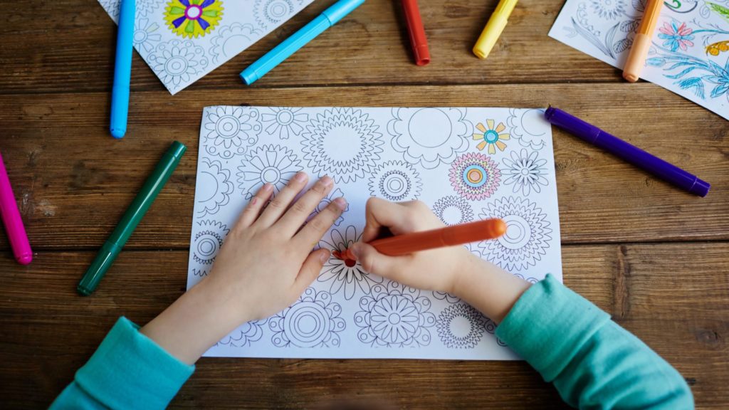 child coloring as a downtime activity to manage the symptoms of jet lag on vacation
