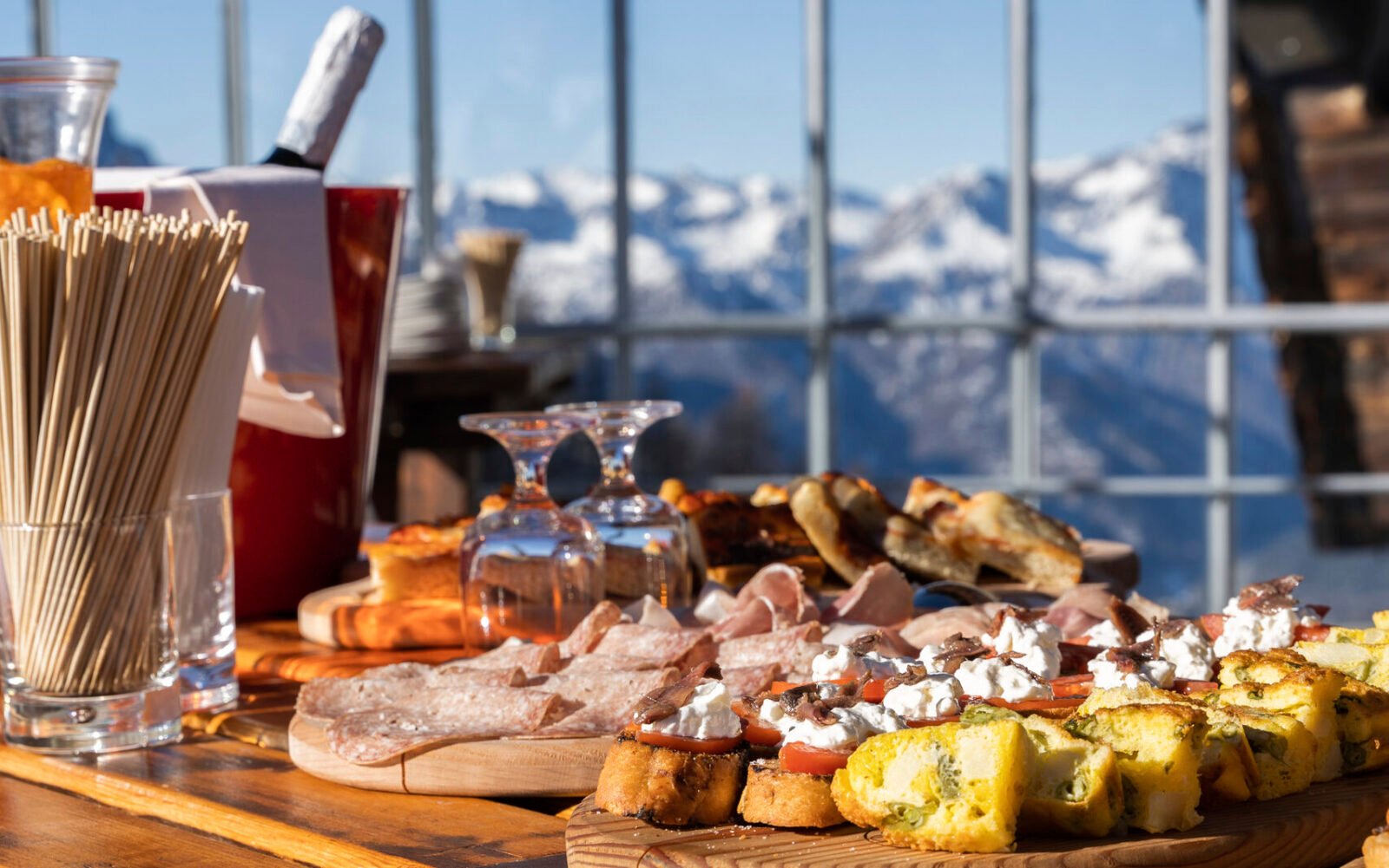 Charcuterie board and chilling wine at Club Med Tignes with snowy mountains in background