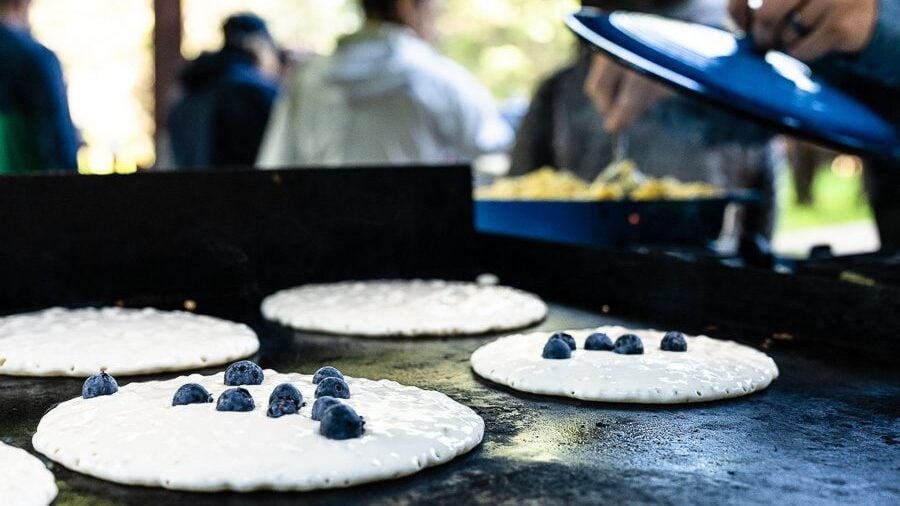Flathead Lake Lodge all-inclusive's Trail Ride breakfast with blueberry pancakes on the griddle