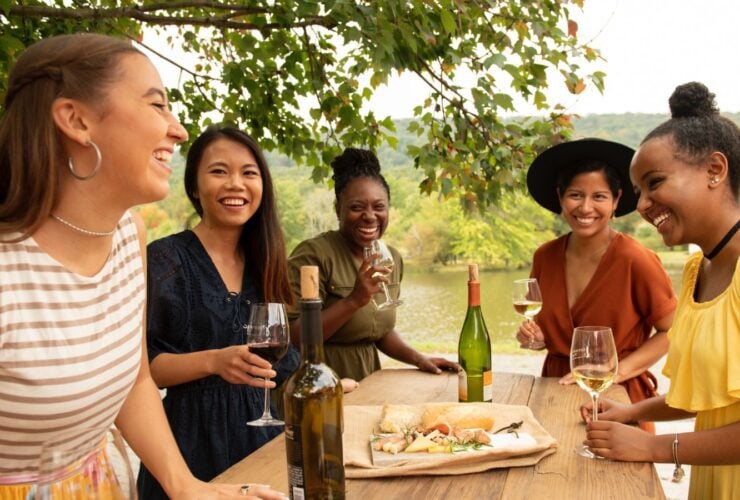 Girlfriends enjoy wine and snacks at a picnic table at Doukenie Winery (Photo: Todd Wright / Visit Loudoun)