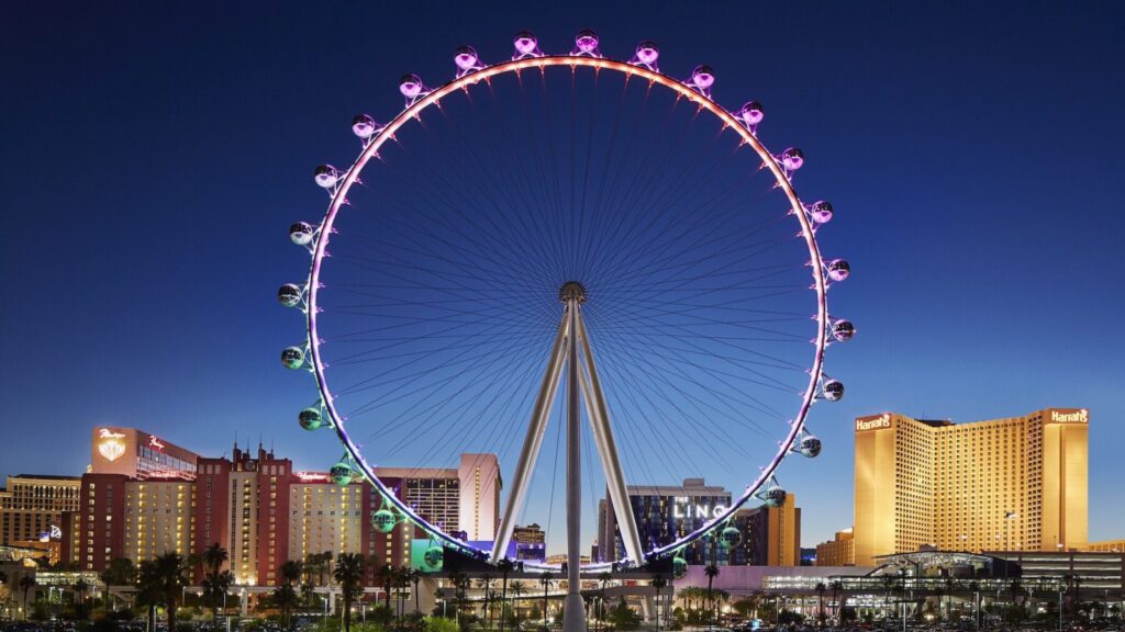 The High Roller Observation Wheel in Las Vegas at dusk with pink and green lighting
