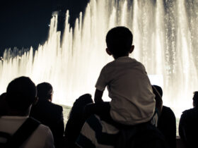 child on an adult's shoulders watching the evening fountain show at the Bellagio in Las Vegas