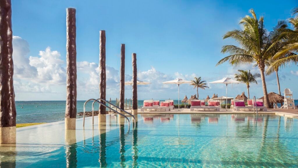 Kolam renang Club Med dengan latar belakang pohon palem