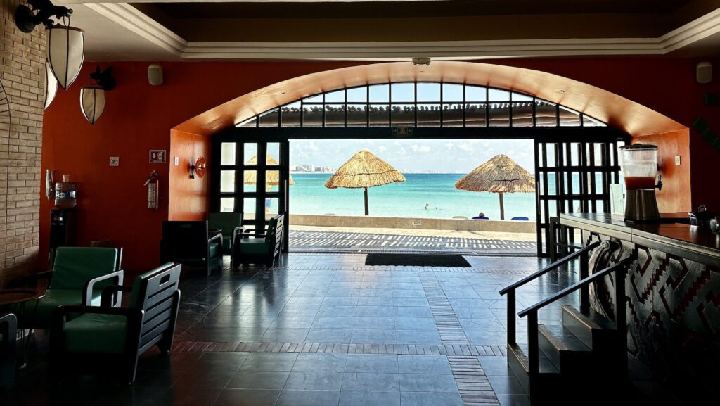 view of bar in main area of Club Med Cancun with beach and Caribbean Sea beyond