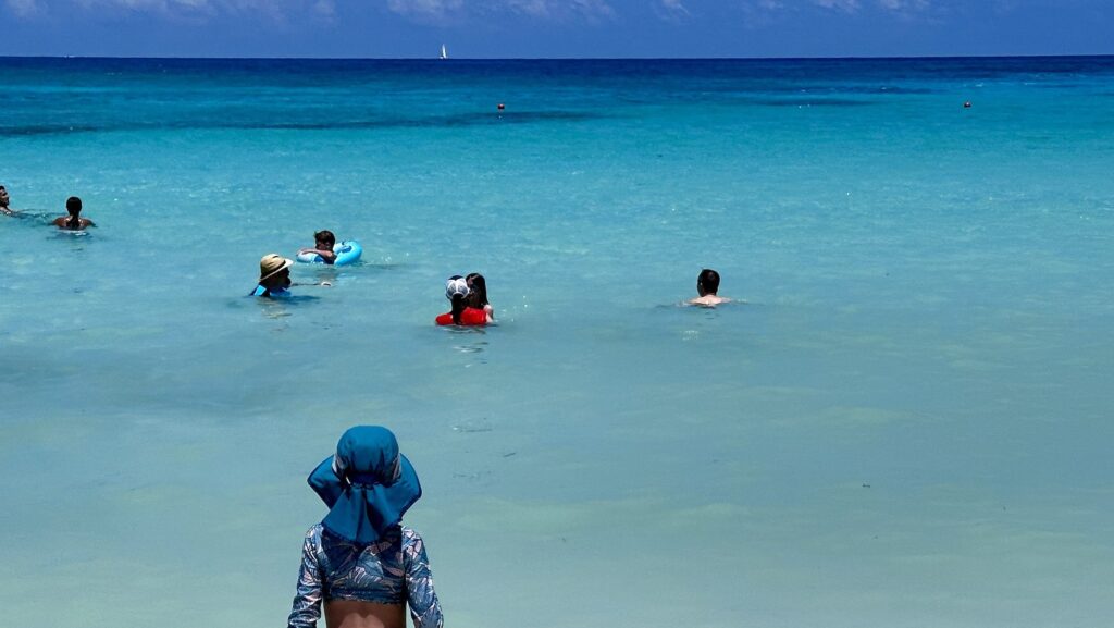 child looking out from Club Med Cancun beach out on people swimming in the Caribbean