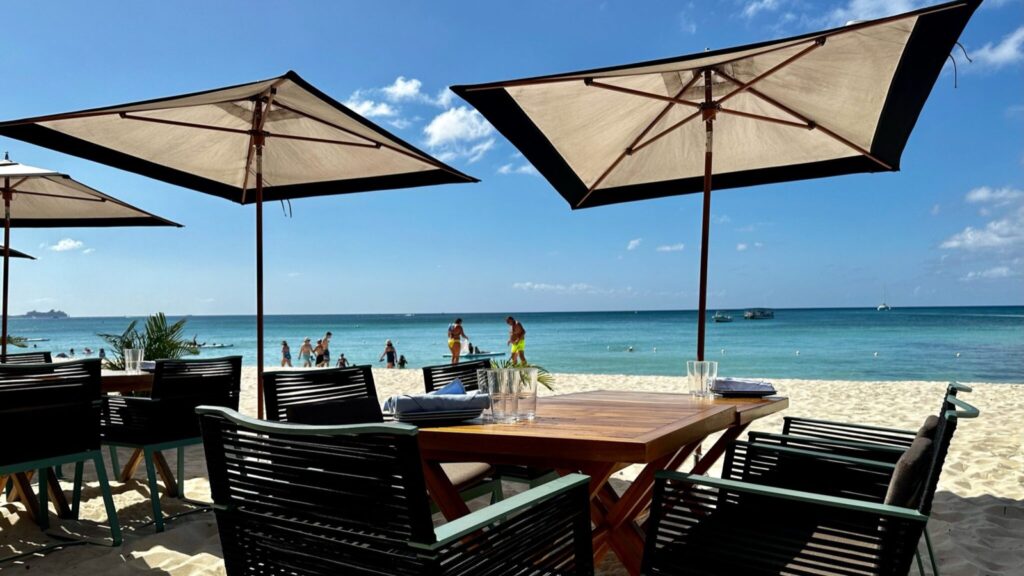 Tables in the sand at the Coccoloba Restaurant at the Seven Mile Beach resort Kimpton Seafire