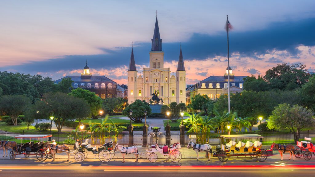 Evening in New Orleans at Jackson Square with illuminated buildings and horses and carriages