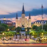 Evening in New Orleans at Jackson Square with illuminated buildings and horses and carriages