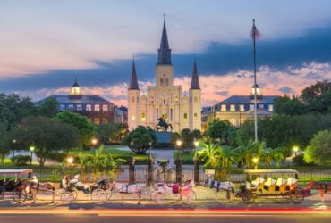 Evening in New Orleans at Jackson Square with illuminated buildings and horses and carriages