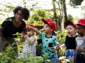 teacher in a garden showing plants to young kids