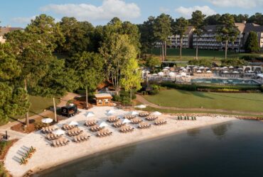 Chairs and umbrellas set up on the lake beach at The Ritz-Carlton Reynolds, Lake Oconee