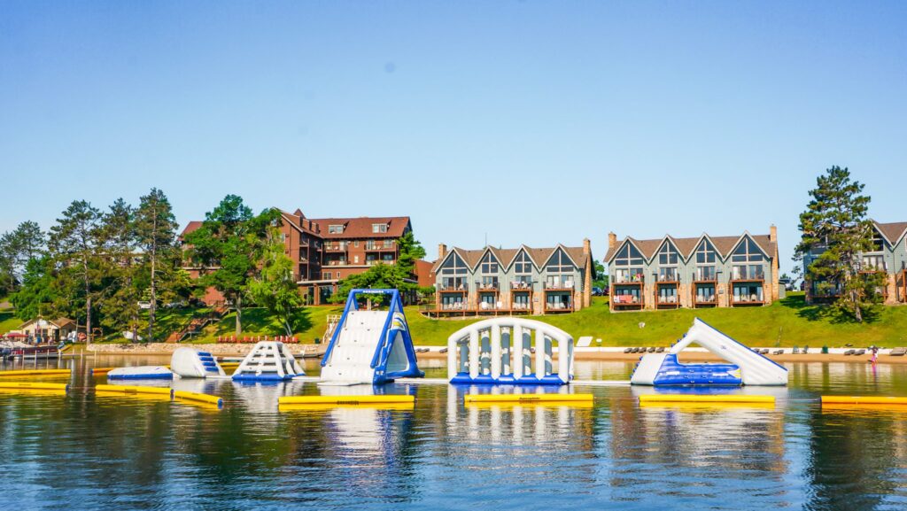 An inflatable water park with slides and climbing structures on the lake at Madden's on Gull Lake