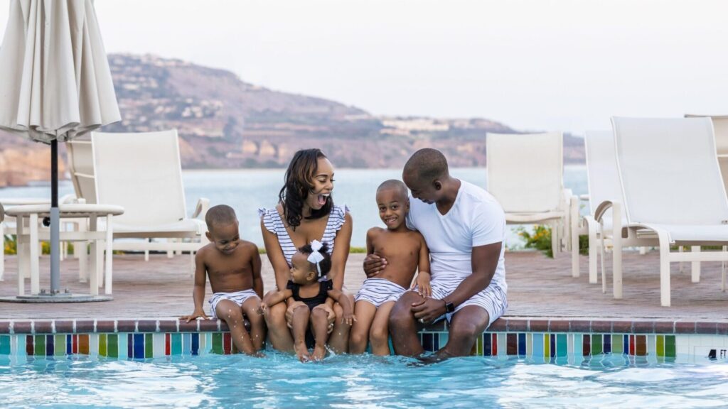 family sitting by the pool at California beach hotel Terranea