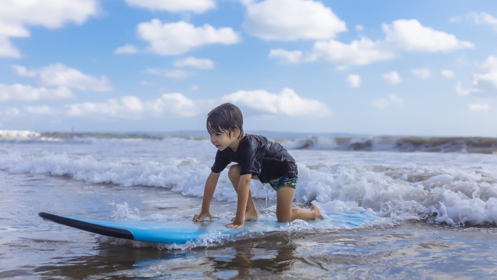 Young child surfing in Bali