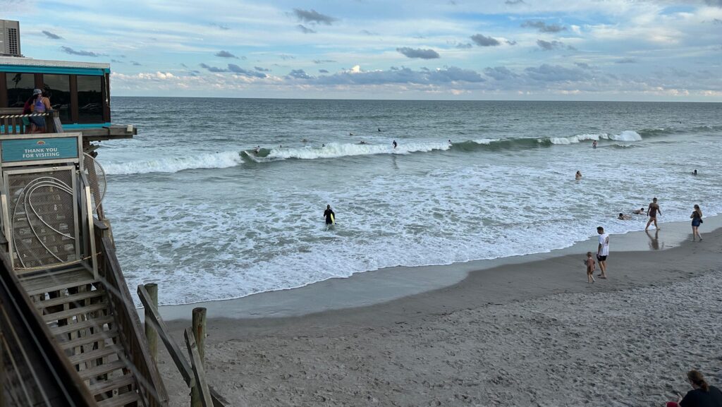 A view of surfers and people at the beach from the Cocoa Beach Pier