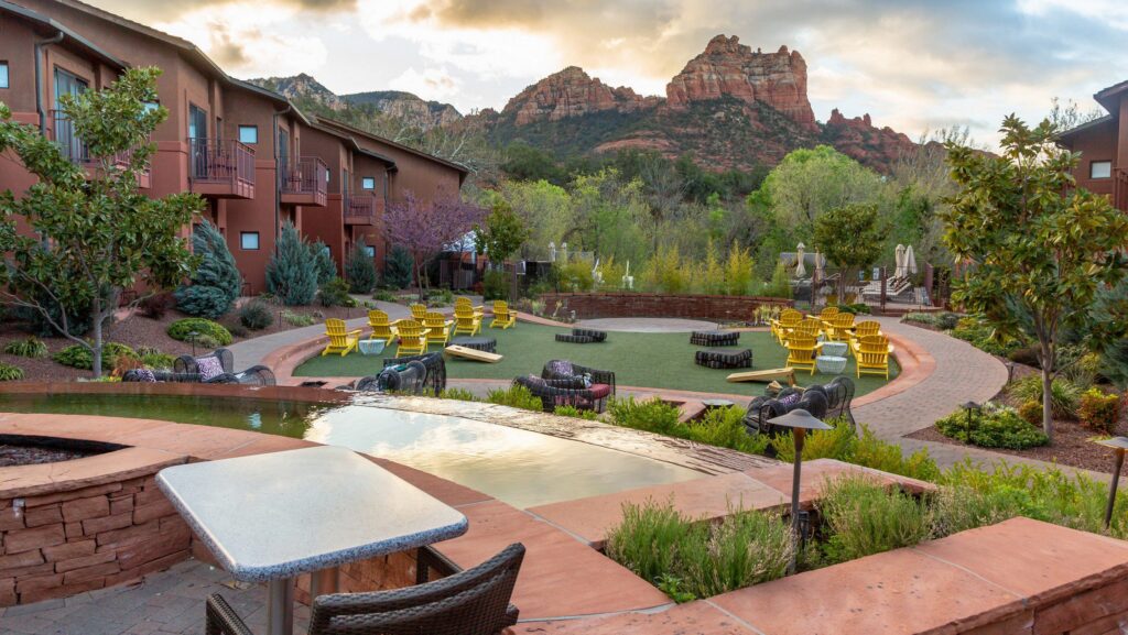 Yellow Adirondack chairs in the courtyard of Amara Resort and Spa with Sedona's red rocks in the distance