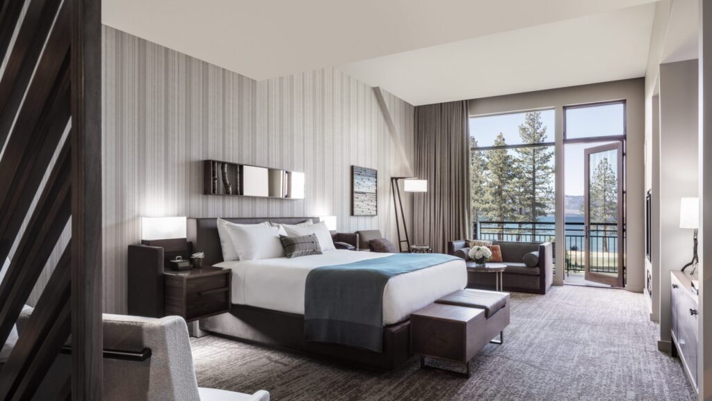 A guest room at Edgewood Tahoe Resort with a view of the lake from the balcony