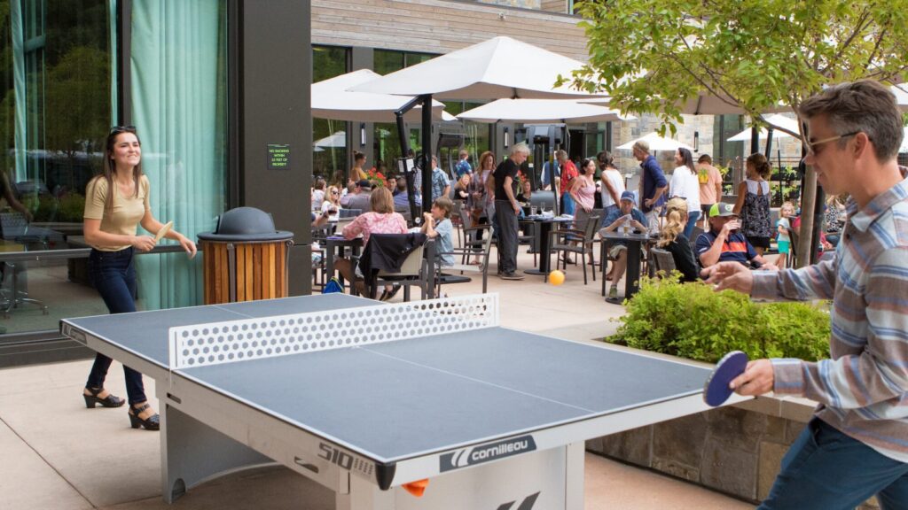 People playing ping pong on the patio at Limelight Ketchum Hotel in Idaho