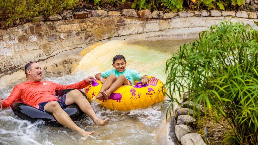 A man and boy on a tube float ride at a water park