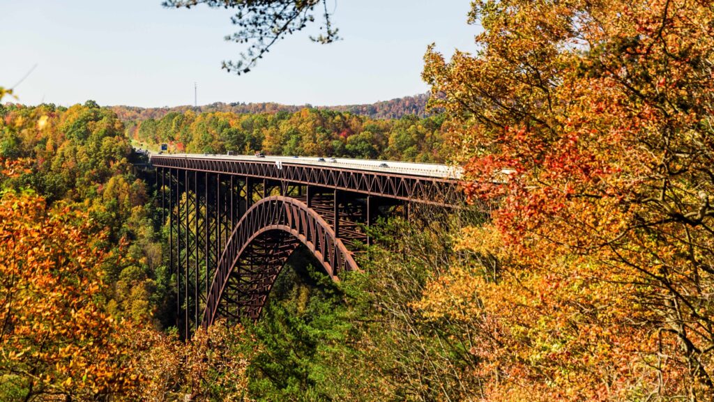 Cars driving along the New River Gorge Bridge during the fall