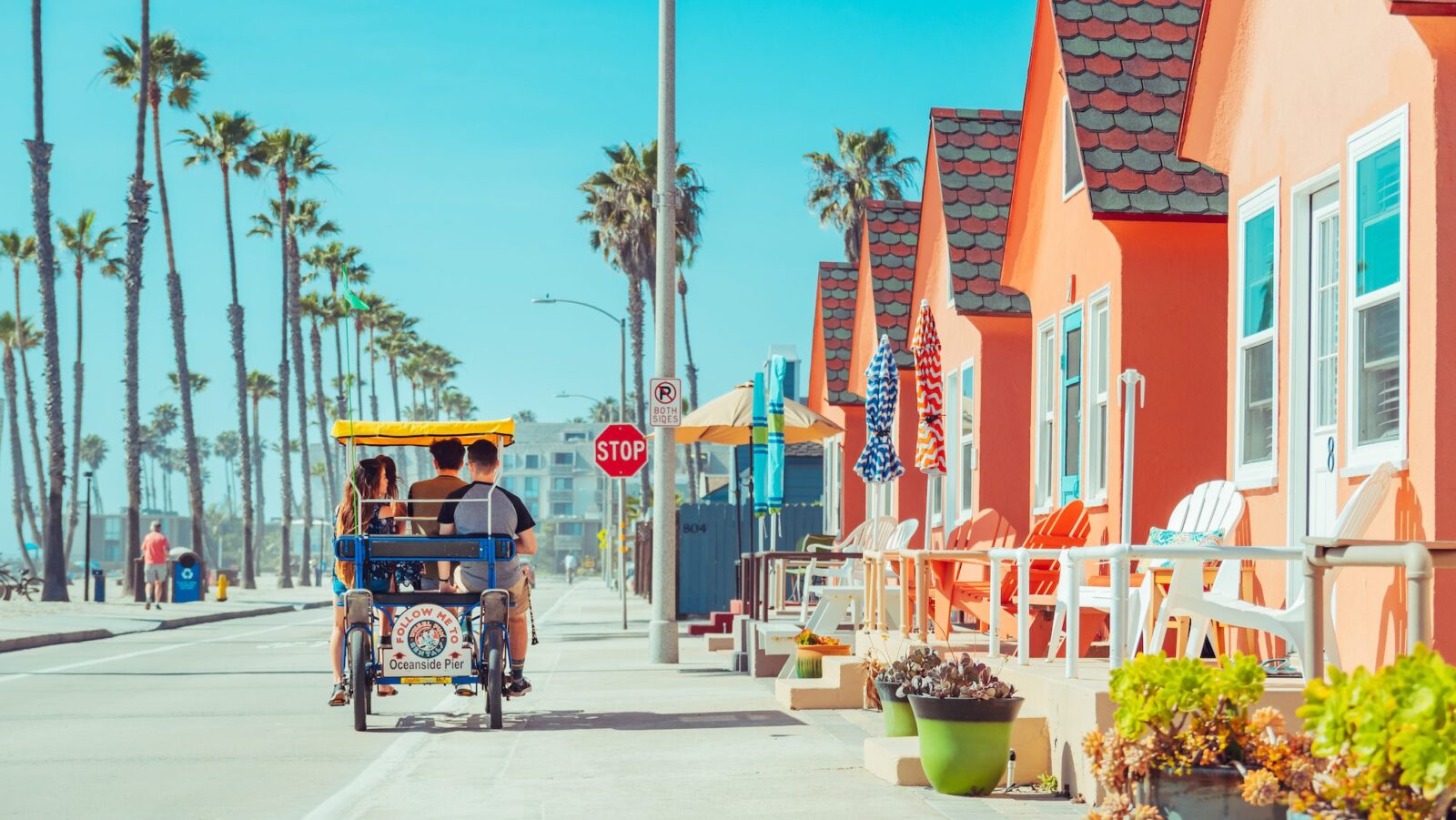 Carriage bike going along the Strand lined by palm trees on a sunny day in Oceanside, California
