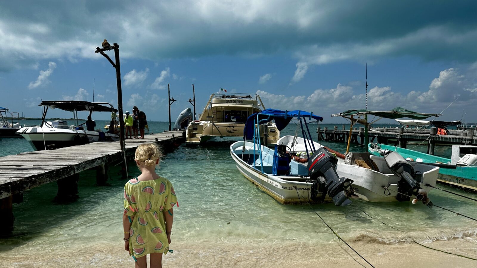 child looking out at boats and dock on Ilsa Mujeres, Mexico