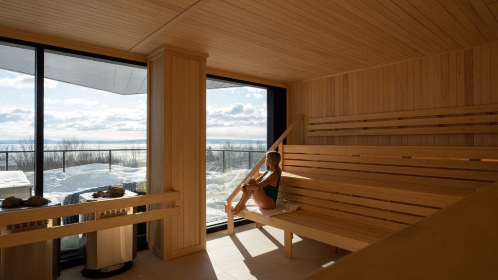 woman in bathing suit in sauna with beautiful snowy landscape views at Club Med Quebec Charlevoix
