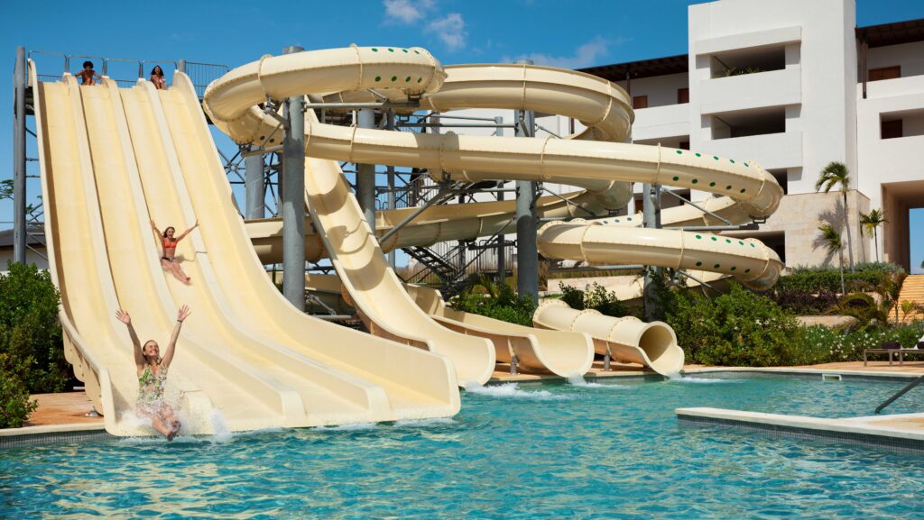 Two people sliding down waterslides at a resort water park