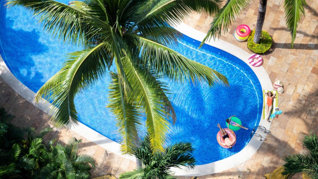 An overhead view of a dad and daughter on pool floats and a mom laying by the pool at Hyatt Ziva Puerto Vallarta