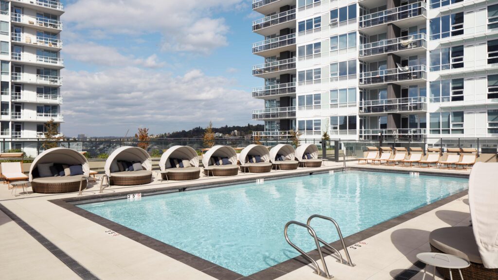 A pool with covered lounge seats at Level Hotels' Seattle property