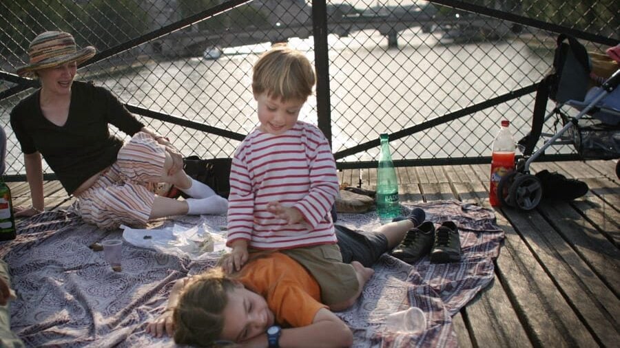 family picnicking at dusk on the Pont des Arts in Paris