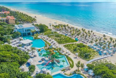 An aerial view of the beach, water park, and pools at Sandos Playacar