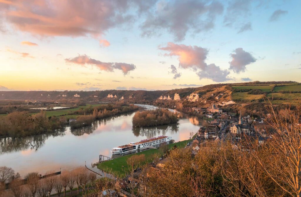 An aerial view of a Uniworld Boutique River Cruise vessel at sunset