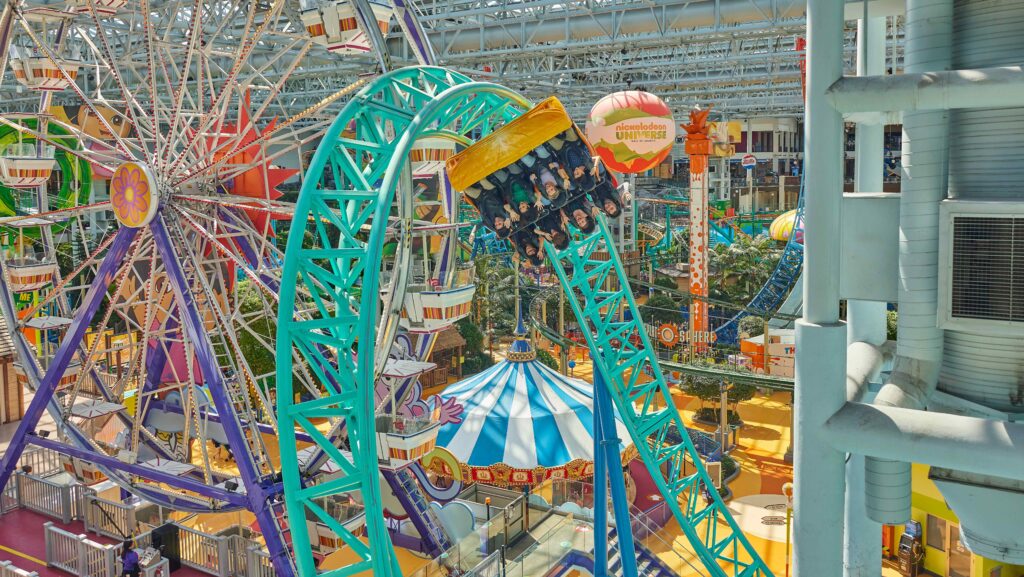 Riders twisting upside down on a roller coaster at Nickelodeon Universe at the Mall of America