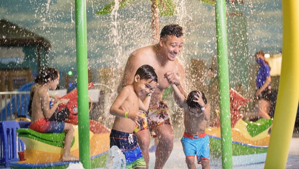 A dad and two kids in a splash zone at Great Wolf Lodge