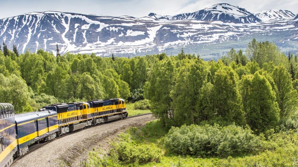 Alaska Railroad train with mountains in background of scenic train trip