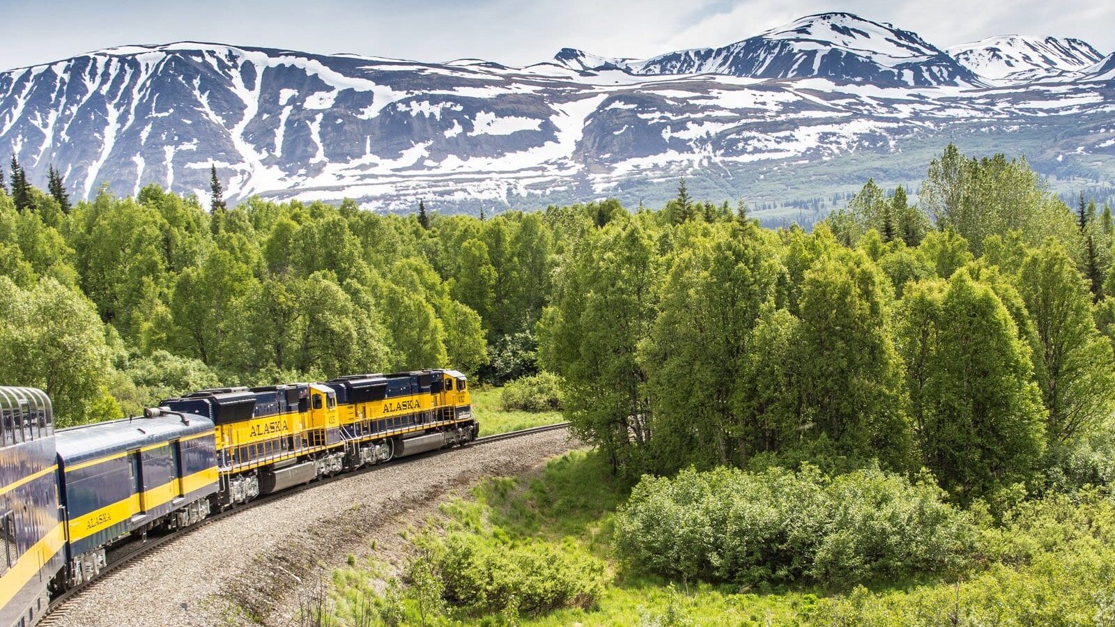 Alaska Railroad train with mountains in background of scenic train trip