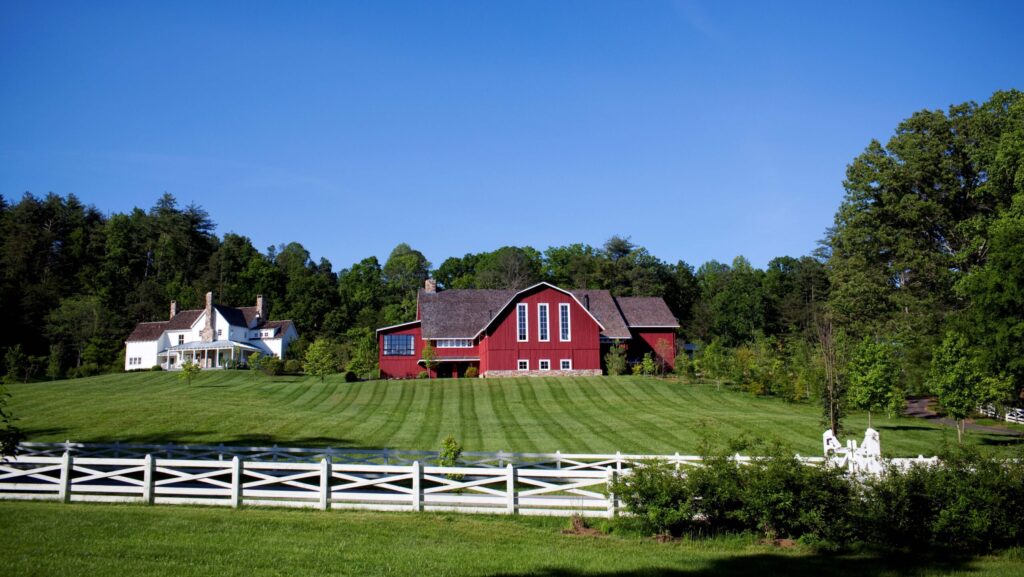 A red barn, white house, and grassy field at Blackberry Farm