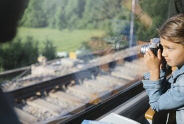 Young child looking out window of a scenic train in Europe