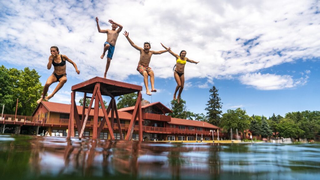 Four kids jumping into Pelican Lake at Fair Hills Resort