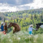 A mom and child visiting with horses at Vista Verde Guest Ranch