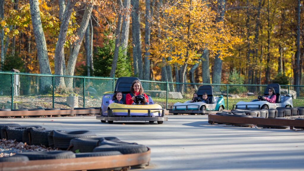 Kids riding in a go-kart during the fall at Woodloch Resort