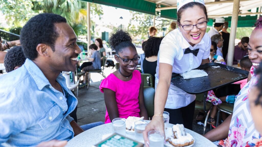 family being served beignets at Cafe du Monde in New Orleans