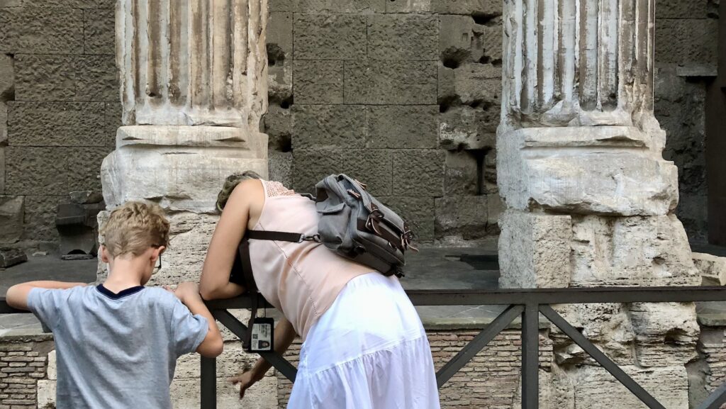 child and adult looking at ruins in Rome