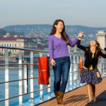 Parents and child on an Adventures by Disney Danube River Cruise, laughing on deck